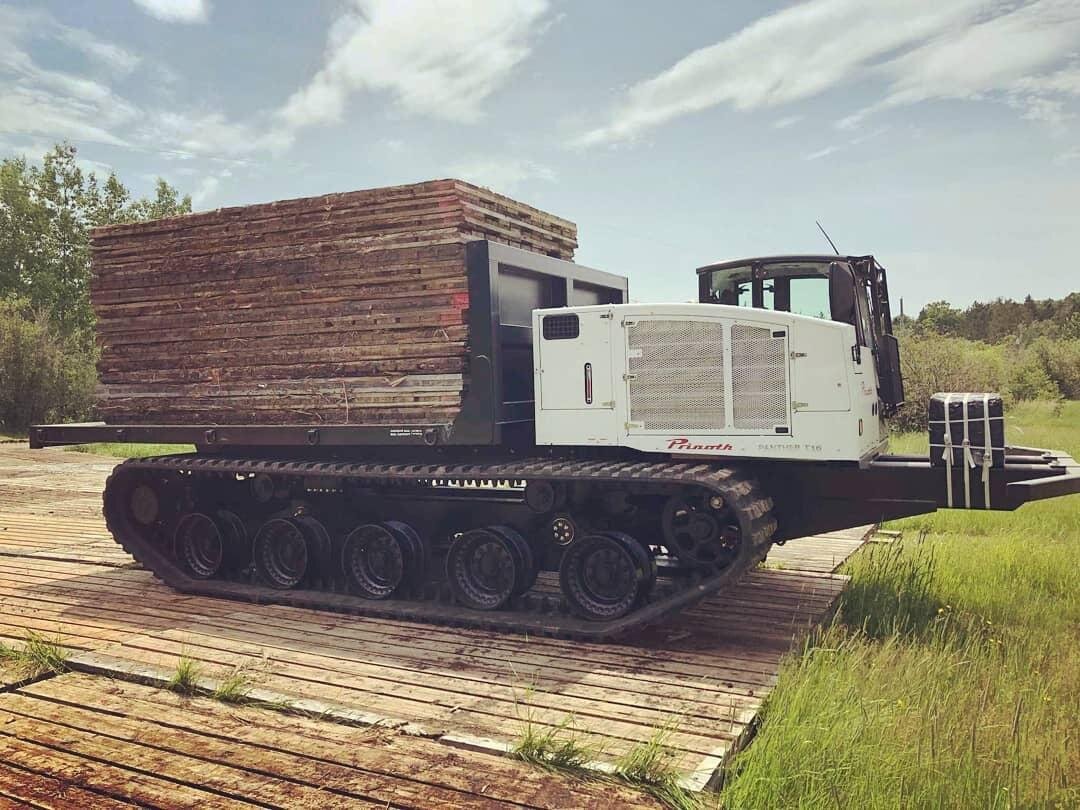 A Panther T16 equipped with a flat deck for transporting mats in pipeline construction projects. This configuration ensures efficient material handling and reliable access across challenging terrain